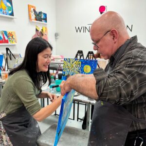 Signing a Coworkers Painting Team Building at Wine & Design Montclair